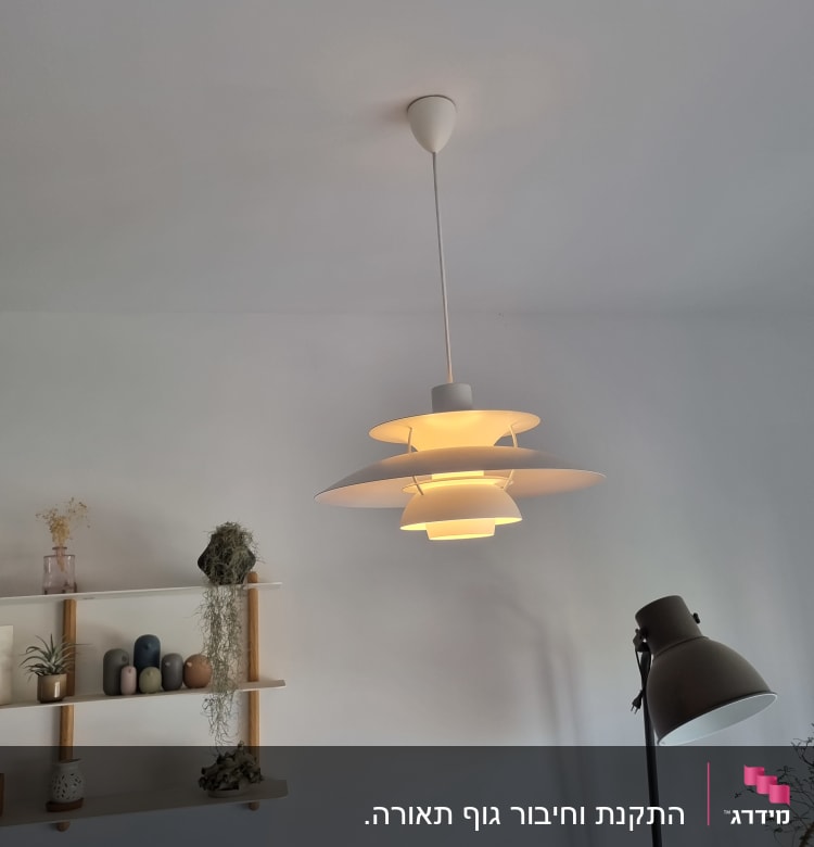 מנורה תלויה עם אור דולק בתקרה לבנה